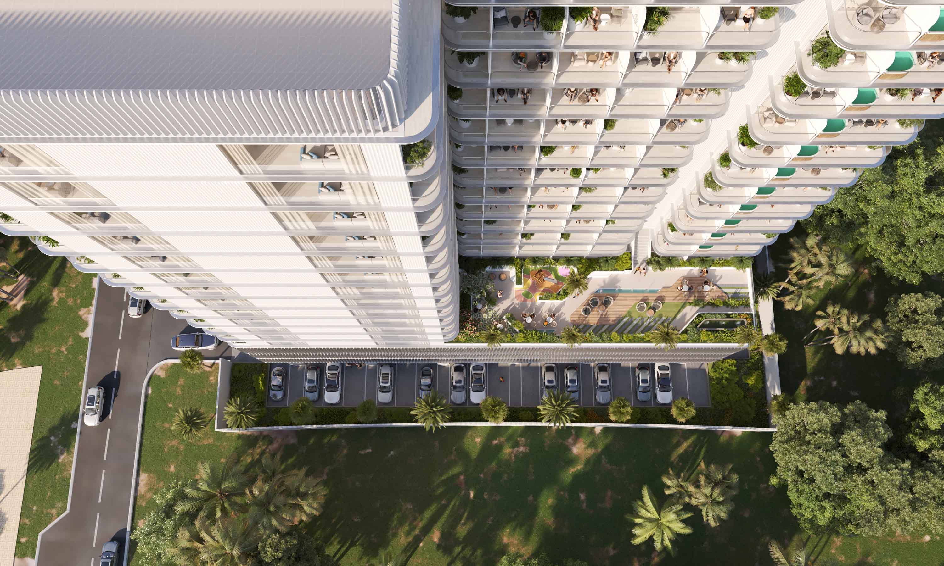 Cove Edition Iii By Imtiaz Aerial view of a modern residential building with balconies, green spaces, and a parking lot below.